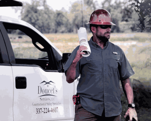 Doucet Services technician on a job site beside a company truck
